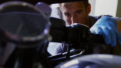 mecánico masculino reparando motocicletas en el garaje de reparación 4k