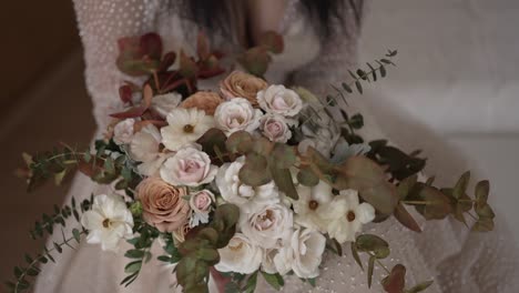 bride holding a soft, romantic bouquet with pastel roses and eucalyptus leaves