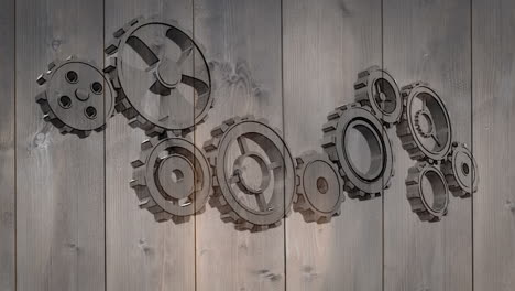 cogs and wheels turning on wooden background