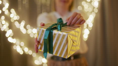 woman hands over a present and is slightly embarrassed