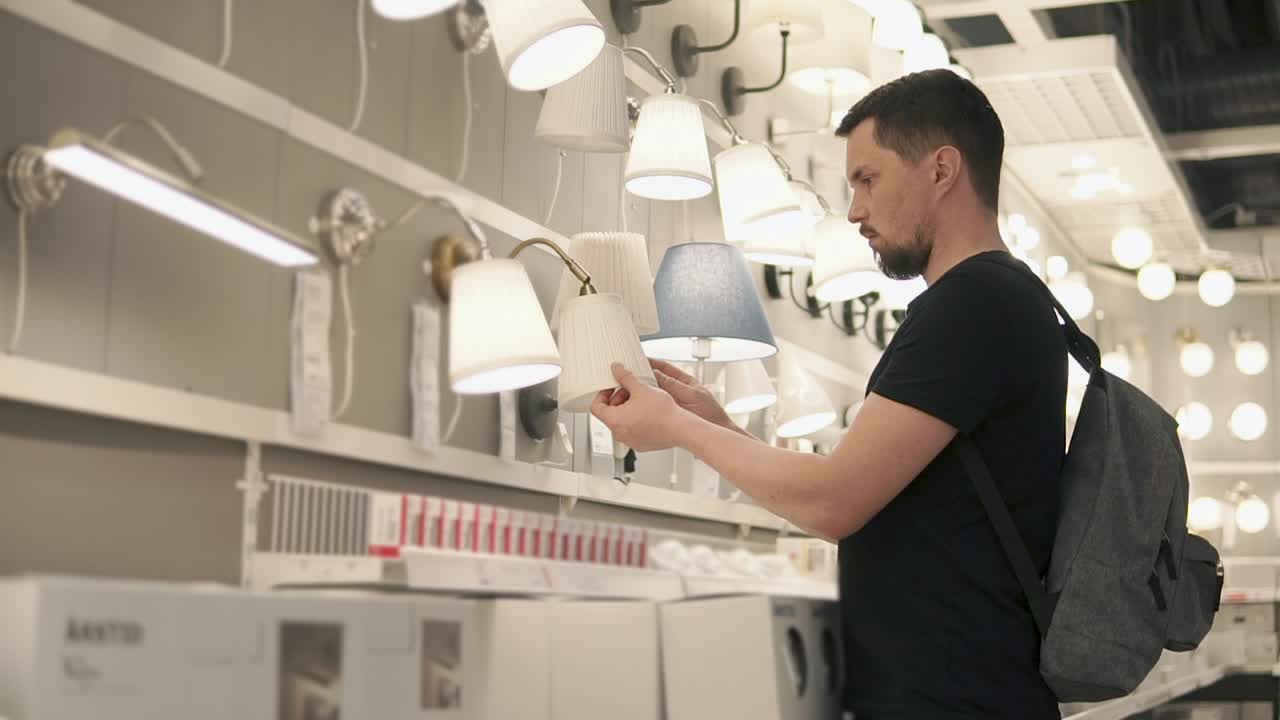 Uomo che fa acquisti di applique in un negozio di illuminazione