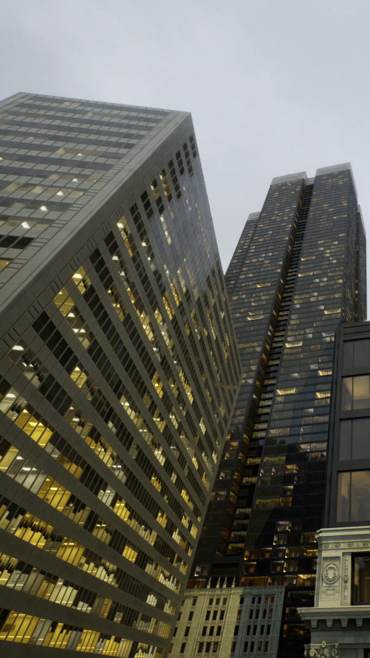 Urban skyline view showing tall buildings with lights on during evening hours