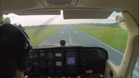 hombre asiático aterrizando un pequeño avión cessna 172, fuertes vientos antes de tocar la pista, aterrizaje inestable