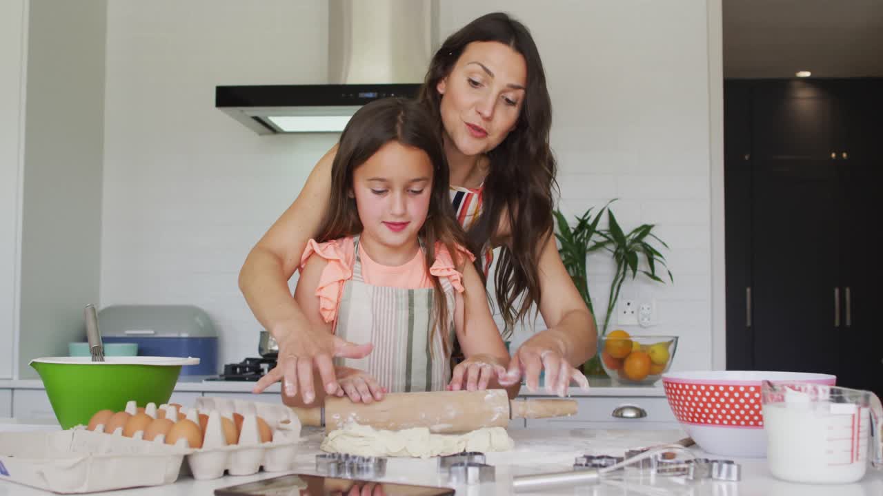 madre y hija caucásicas felices horneando juntas en la cocina