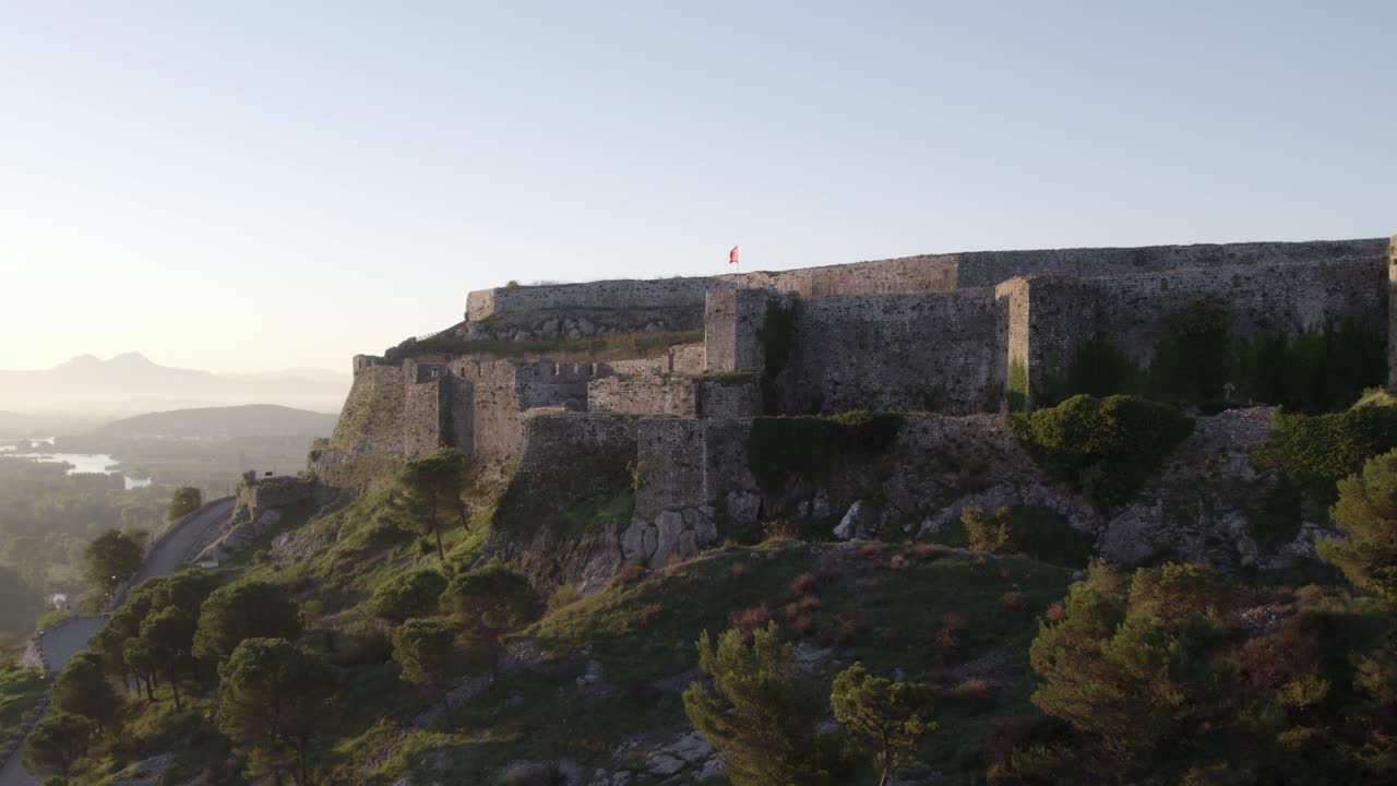 Volando in avanti verso Schloss Shkodra con la bandiera albanese che sventola, ripresa aerea