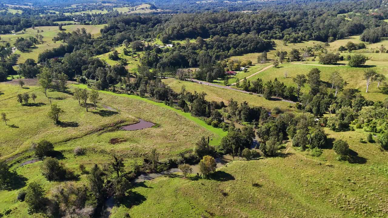 Drone footage captures expansive views of Nimbin Rocks, lush eucalyptus forests, and grasslands under clear skies