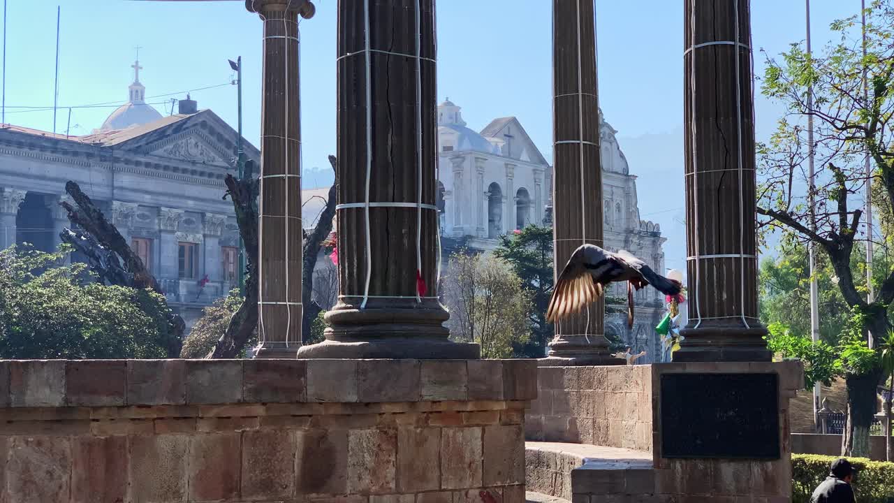 중앙 아메리카 과테말라 도심 공원의 배경에 교회가 있는 신고전주의 기둥 구조