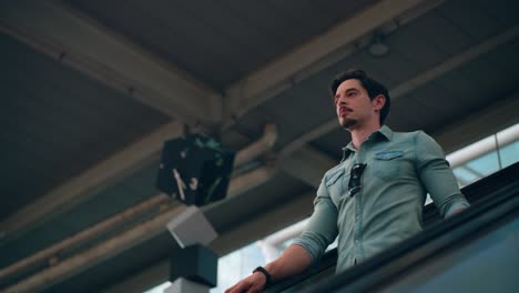 man traveler in 40s riding escalator down at seoul train station - tracking shot