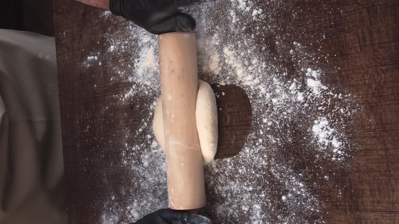 A baker preparing bread and kneading it