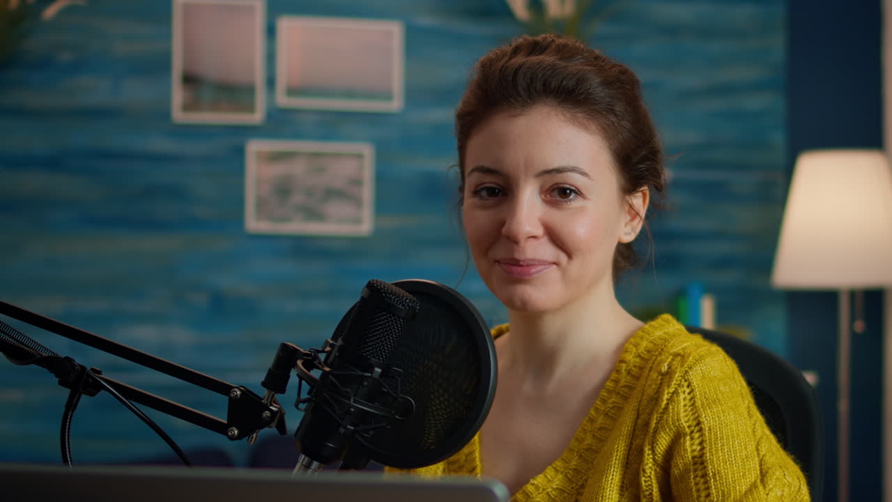 Social media influencer smiling at camera sitting in home studio