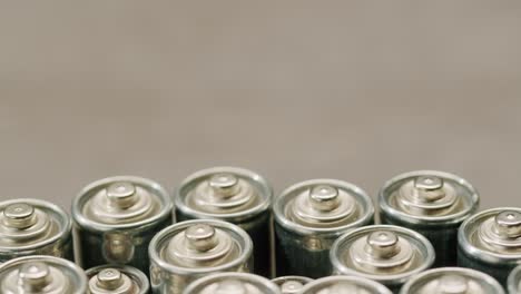 silver batteries aa and aaa on black background close-up. double-a battery is a standard size single cell cylindrical dry battery. batteries are common in portable electronic devices. an aa battery is composed of a single electrochemical cell that may be either a primary battery or a rechargeable ba