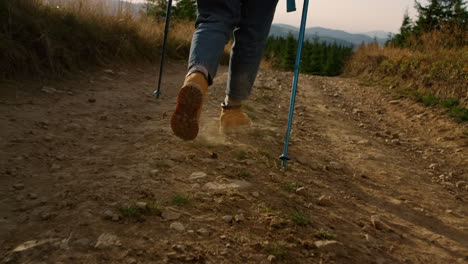 mujer caminando por el camino de tierra en las montañas