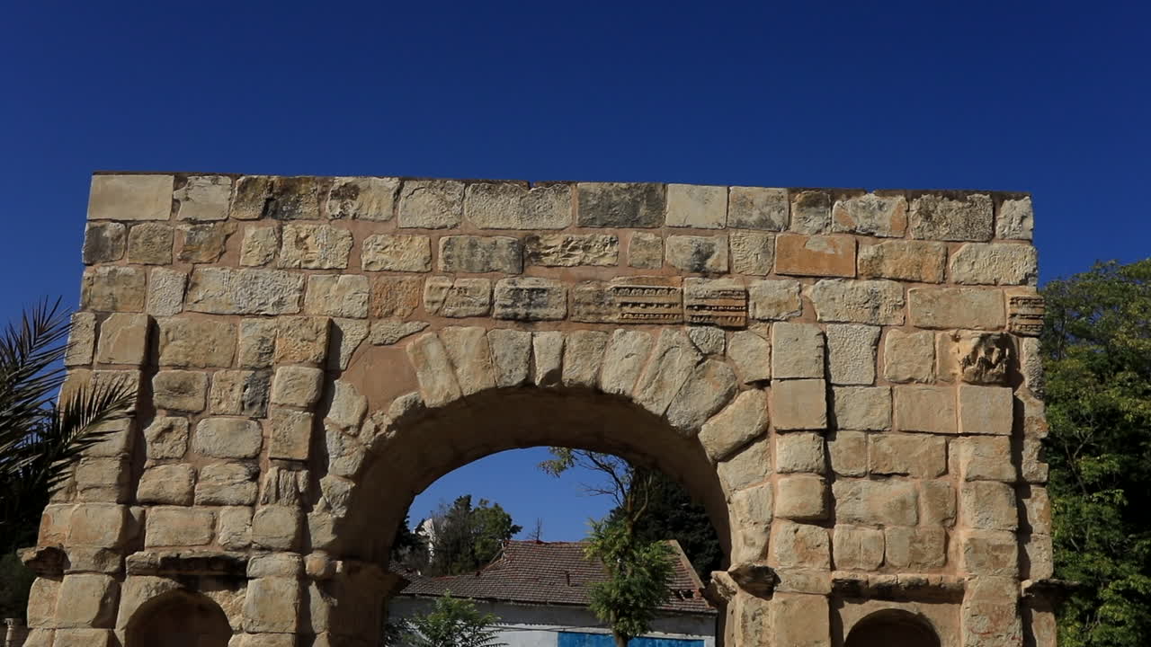día soleado en dougga con un cielo azul claro enmarcando las antiguas ruinas del arco romano
