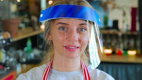 woman wearing face shield in a cafe