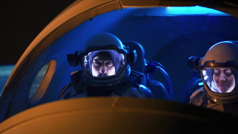 astronauts in spacecraft cockpit at night