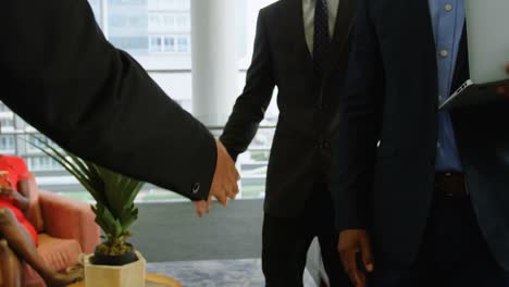 Businessmen-shaking-hands-in-office-4k