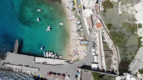 Drone-slowly-moving-forward-above-San-Nicola-beach-and-harbor-at-Tremiti-islands-during-a-sunny-day