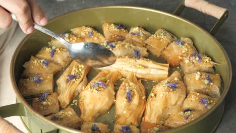 hand serving baklava with spoon