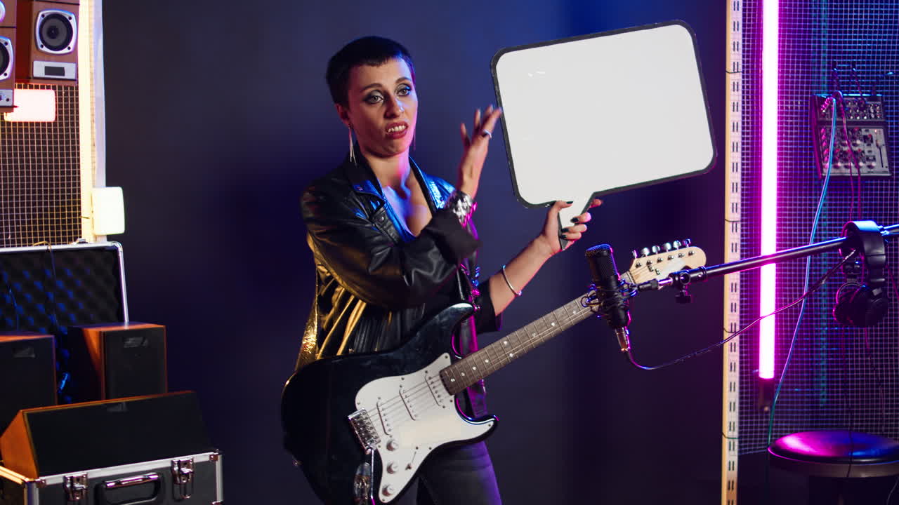Woman with Guitar Holding Speech Bubble in Recording Studio