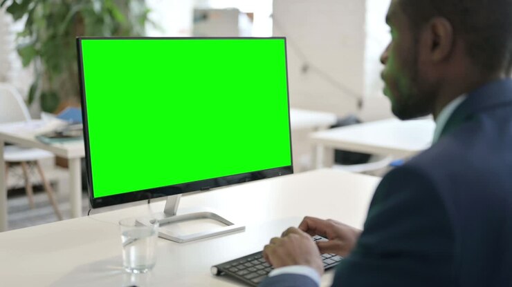 Geschäftsmann arbeitet am Desktop mit grünem Greenscreen.
