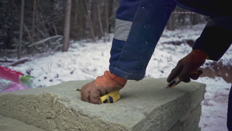 construction worker measuring insulation in winter