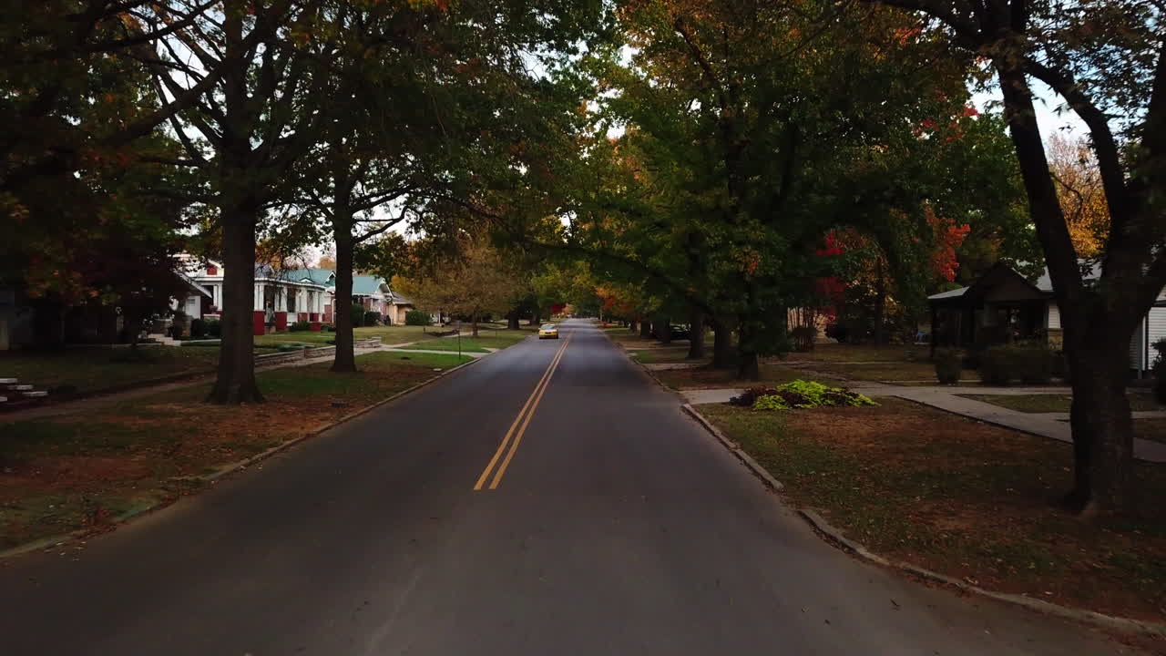 거리를 운전하는 노란색 택시 기사의 느린 공중 후방 돌리