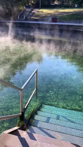 a hot spring with steaming water and steps