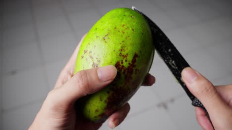 Hands-Cut-Ripe-Avocado-Fruit-In-Half-With-Knife-Showing-Pit-Inside,-Close-Up