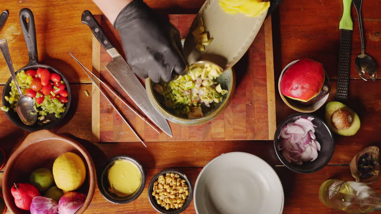 preparación de ceviche - vista superior de la mesa de un chef profesional tirando y mezclando ingredientes frescos en un tazón, concepto de escena de cocina