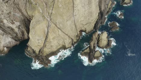 Acantilados-Irregulares-Con-Agua-Azul-Del-Océano,-Isla-De-Roca-Volcánica-En-El-Atlántico,-Antena