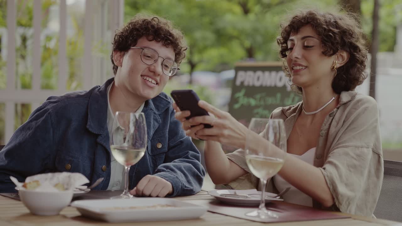 Friends enjoying an outdoor meal and smartphone interaction
