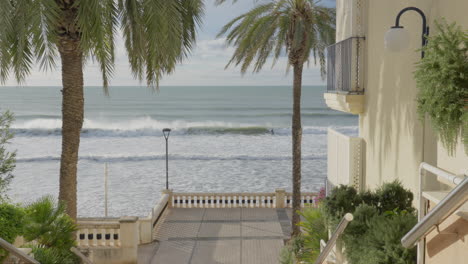 Beach-housing-estate-by-the-sea-with-surfers-riding-waves-in-distance