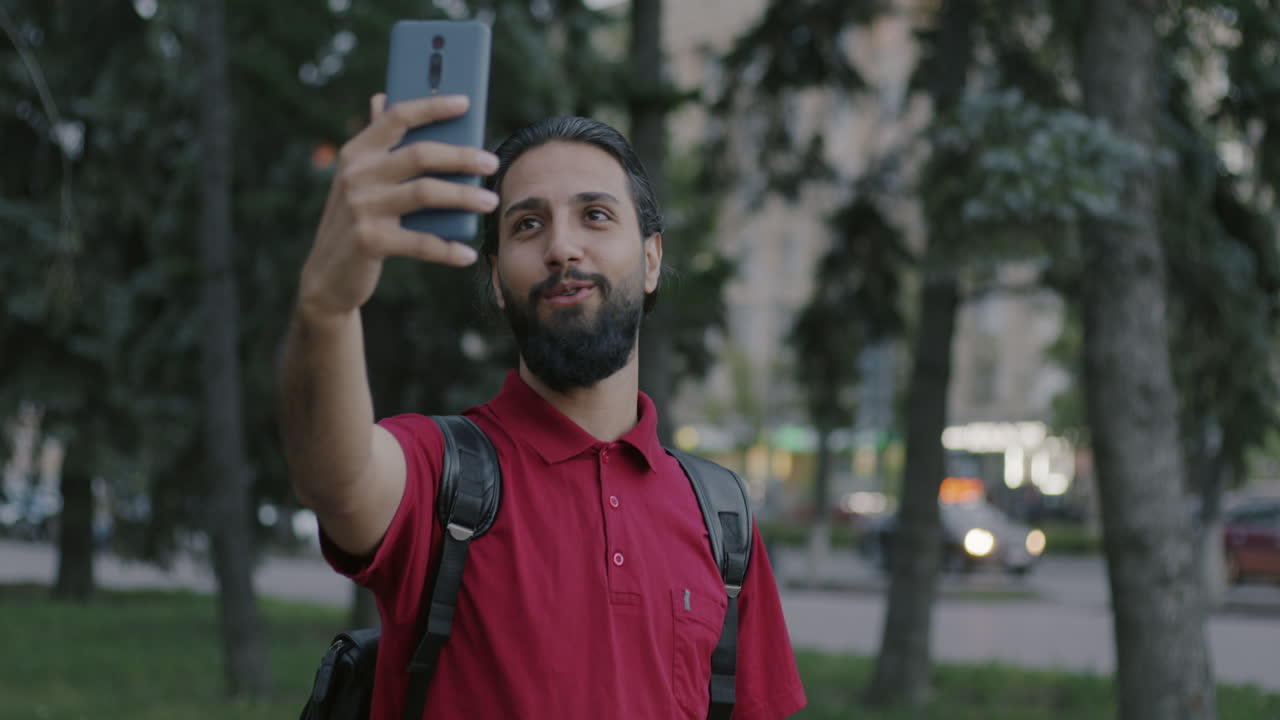 Homem tirando selfie num parque