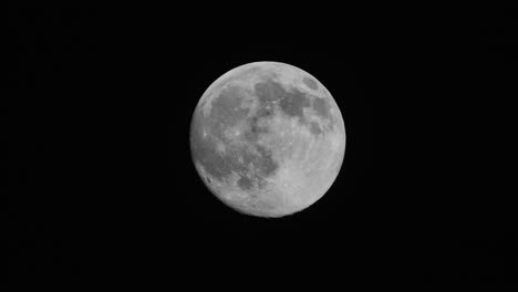 full moon moves quickly in the dark sky