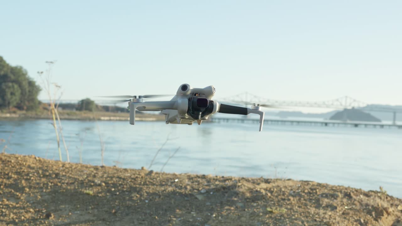 A quiet moment unfolds as a drone floats above the sandy shore, Richmond-San Rafael Bridge arching in the distance