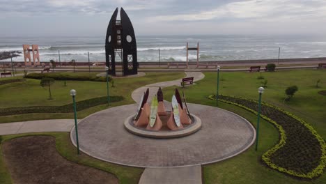 artistic monument in a park near a beach, made of surfboards propped up in a circle