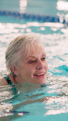 smiling senior woman swimming in a pool