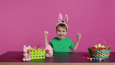 smiling cute kid playing peek a boo game with painted colorful eggs