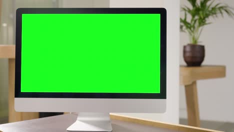 apple imac computer with green screen on office table