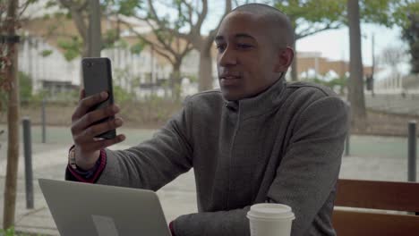 happy african american man having video chat via smartphone