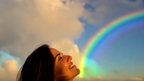 woman gazing up at a rainbow in the sky