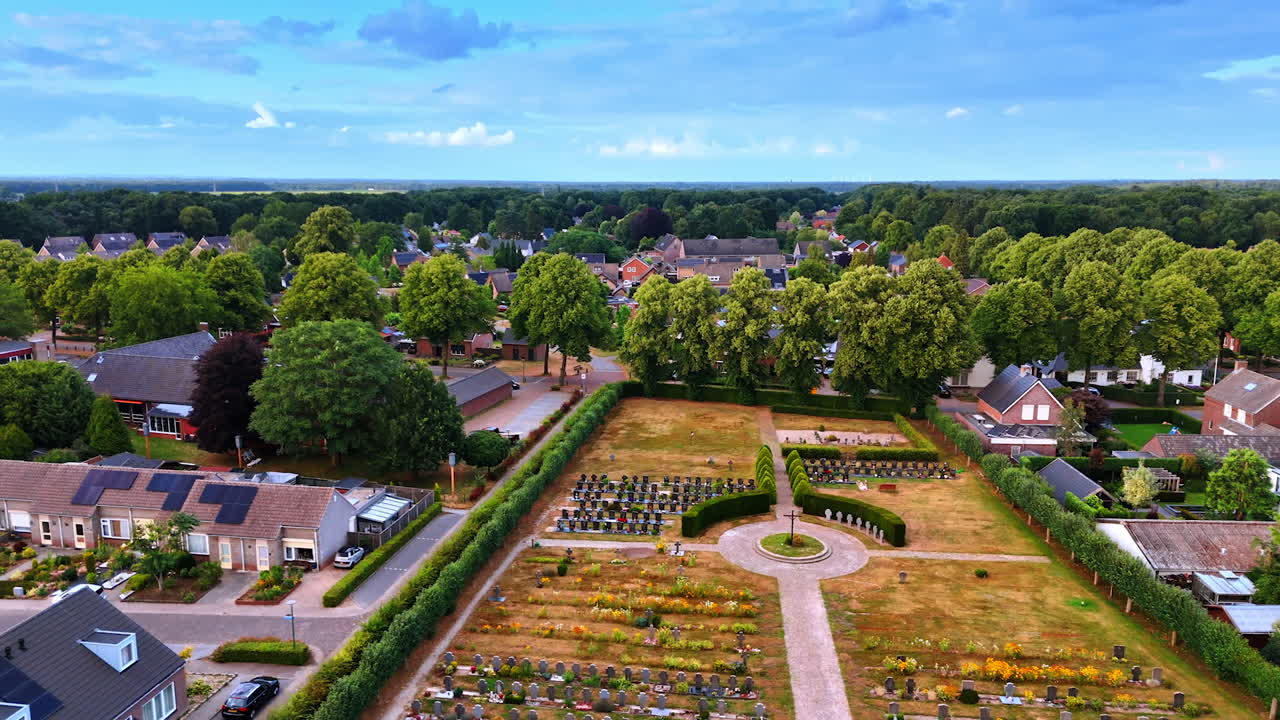 Footage over the cemetery locate din the middle of the town. Green panorama of the residential area around. The Netherlands