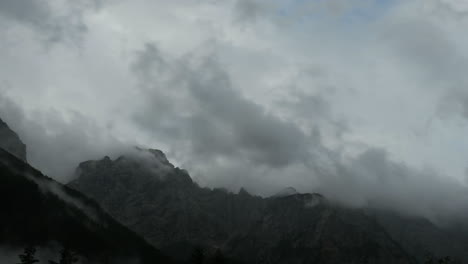 time lapse of clouds over mountain peak, dramatic stormy sky, forest in foreground, ojstrica peak in kamnisko savinjske alpe, logarska dolina, slovenia, european alps