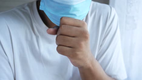 person wearing mask and coughing