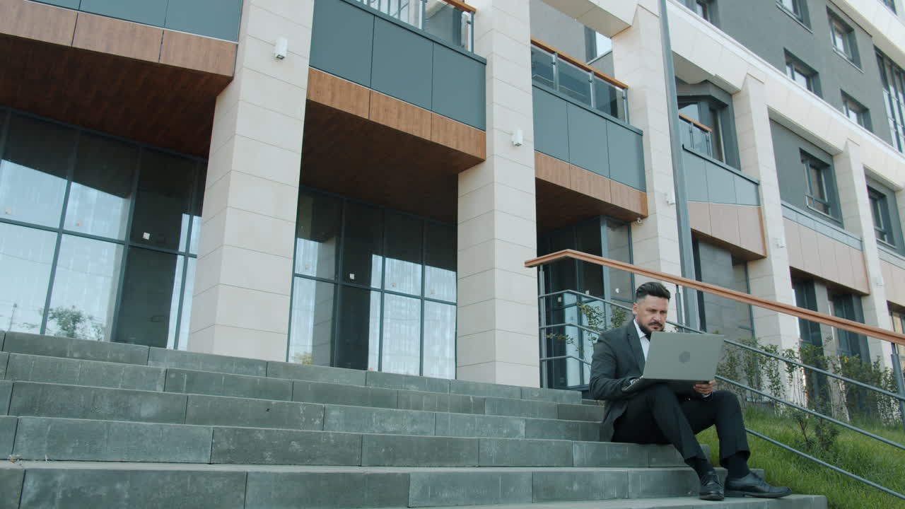 Businessman Working on Laptop on Stairs