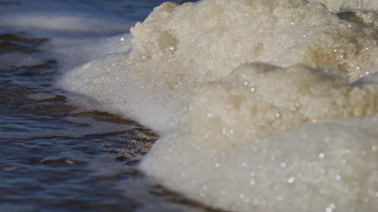 Foamy water waves crash near the Oosterschelde storm surge barrier in Zeeland, super slow motion