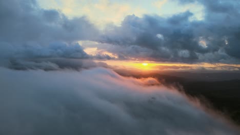 aerial drone high above fluffy white clouds in sky at sunset, 4k