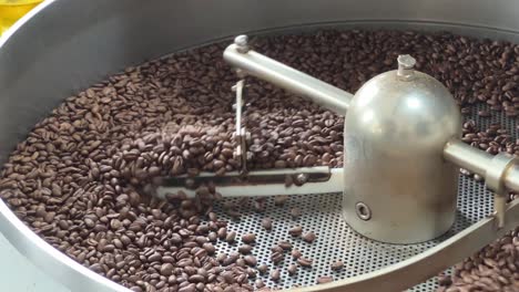 granos de café aromáticos tostados y enfriados en la placa de la máquina, aumento del precio de los productos básicos, concepto de inflación de la cadena de suministro