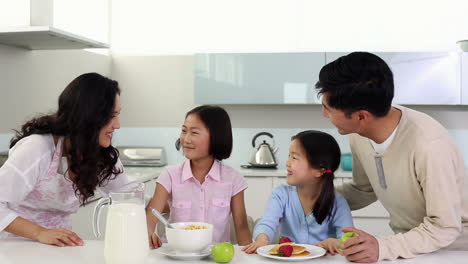 parents serving breakfast to their cute daughters