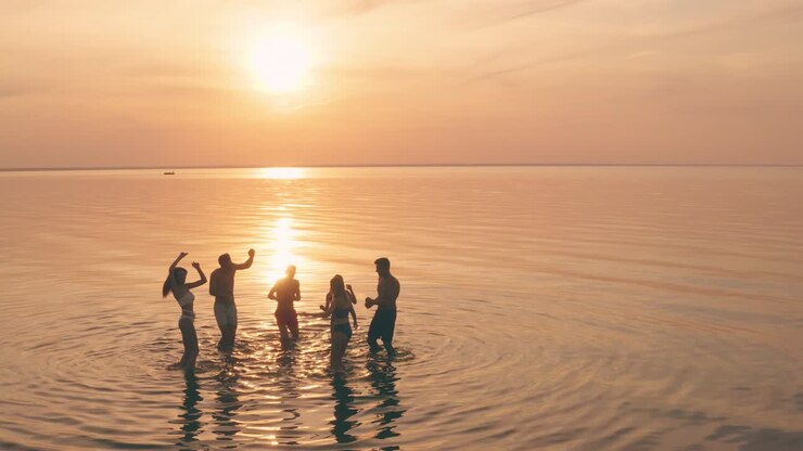 The young people having fun and dancing on the water